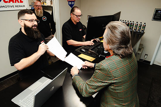 Pro Auto Care team serving a customer at front desk